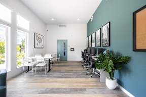 A room with a blue wall and a white table with chairs.