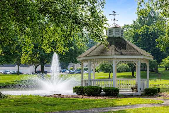 A gazebo with a fountain in front of it.