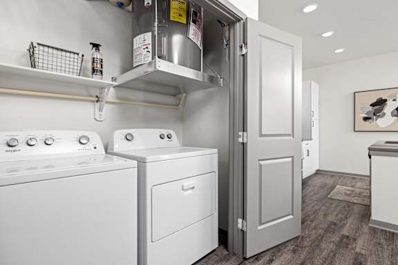 a white washer and dryer in a room with a refrigerator and a door at The Depot Luxury Apartment Homes, Raymore, 64083
