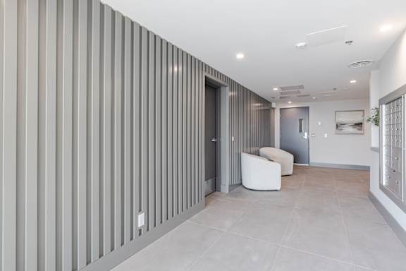 A modern room with a white chair and a grey wall.