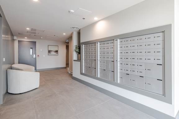A white reception area with a large white table and a white wall with a framed picture.