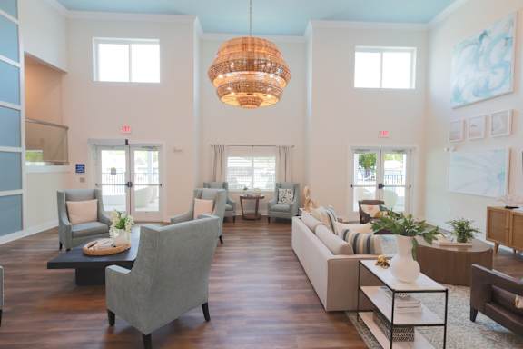 A living room with a grey couch and a wooden floor.