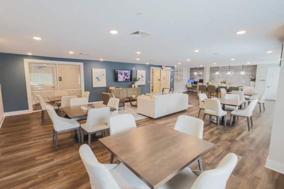 A spacious room with a long table surrounded by chairs.