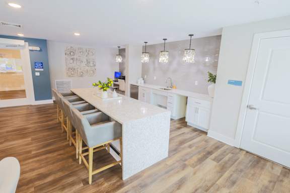 A kitchen with a long island and chairs.