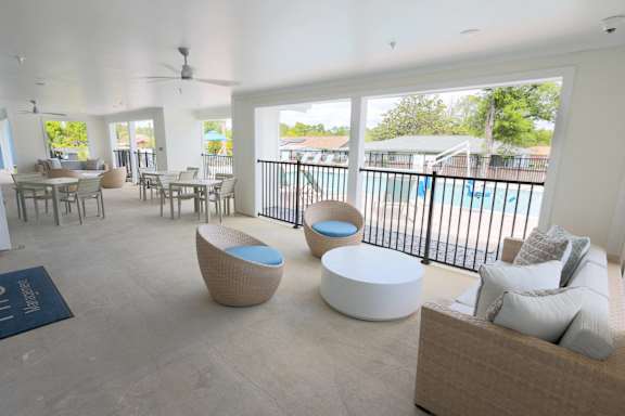 A spacious living room with a pool in the backyard.
