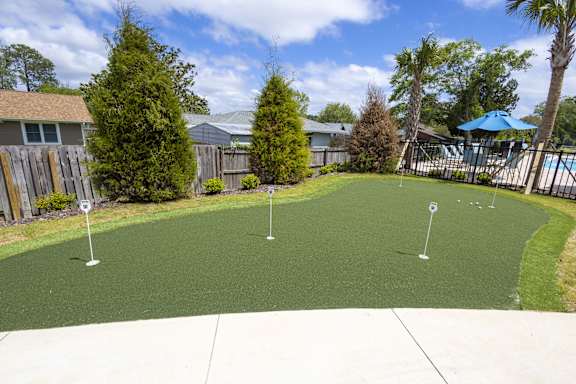 A backyard with a green lawn and a pool table.