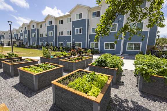 Apartment complex with a garden in front.