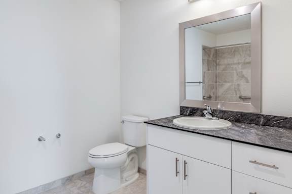A white toilet sits next to a sink in a bathroom.