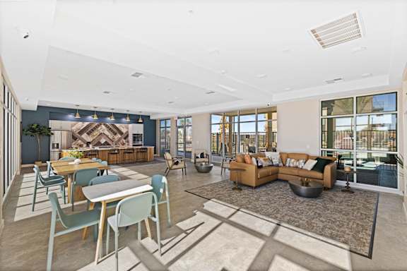 A modern living room with a dining area and a kitchen in the background. at Agave House Apartments, Casa Grande, 85122