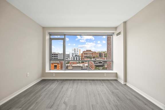A room with a large window overlooking a cityscape.
