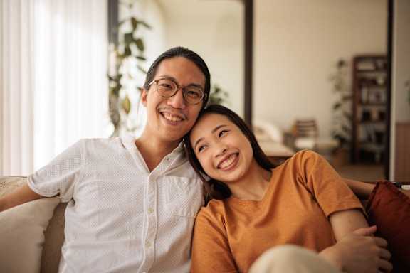 A man and a woman are sitting closely together on a couch.
