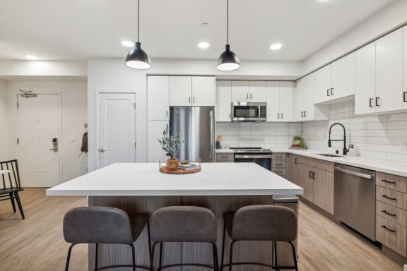 an open kitchen with a large white island with four chairs at 38° NORTH, Santa Rosa, CA 95404