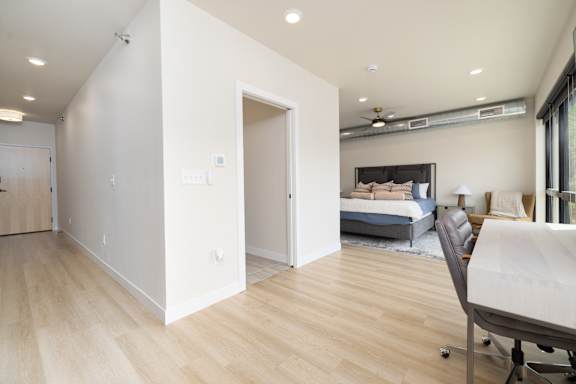 A room with a bed and a chair in it.