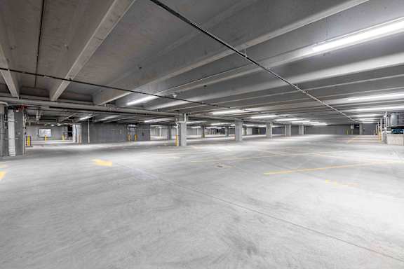 A large, empty parking garage with concrete floors and yellow lines.