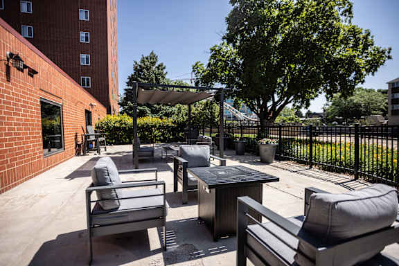 A patio with a table and chairs is surrounded by a black fence.