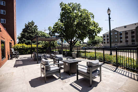A patio with a table and chairs and a tree.