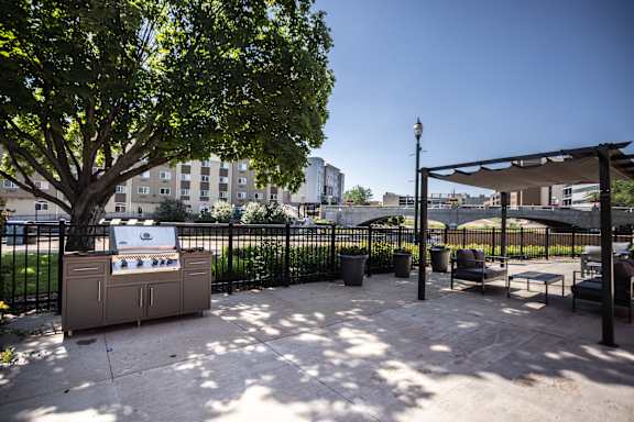 A BBQ grill is in the middle of a concrete patio.