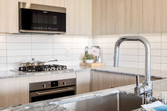 A modern kitchen with a stove, oven, and a microwave mounted above the stove.