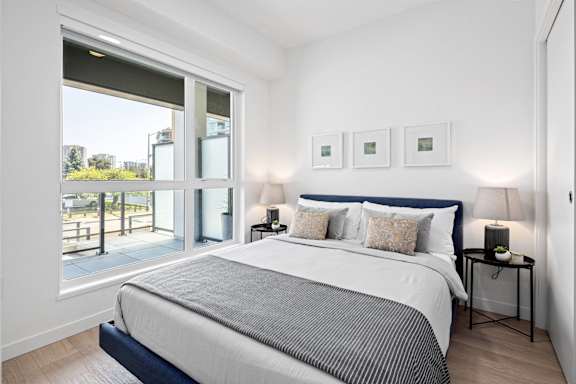 A bedroom with a large bed and a view of the outside.