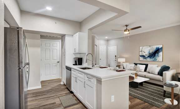 a kitchen and living room with a white counter top