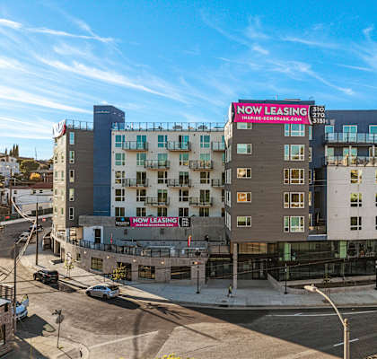 A multi-story building with a "Now Leasing" sign on the side.