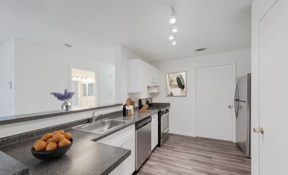 A kitchen with a bowl of fruit on the counter.