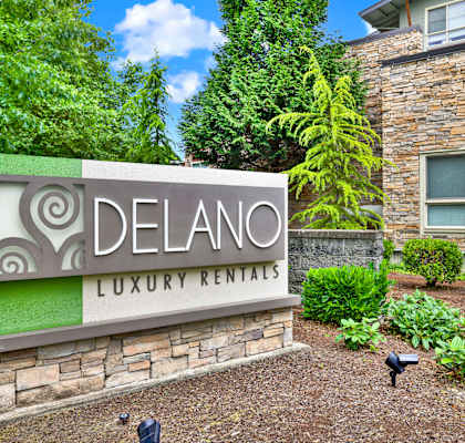 A sign for Delano Luxury Rentals in front of a building.