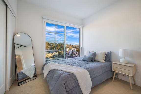 a bedroom with a bed and a large window