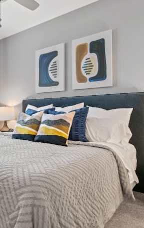A bedroom with a bed, nightstand, and a ceiling fan.