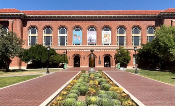 a large brick building with a statue in front of it