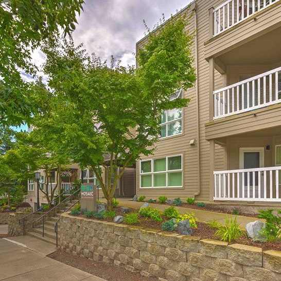 a building with trees and a sidewalk in front of it
