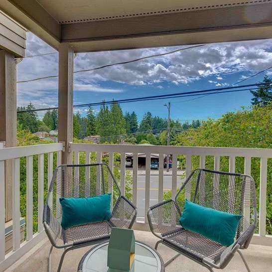 a patio with two chairs and a table on a balcony