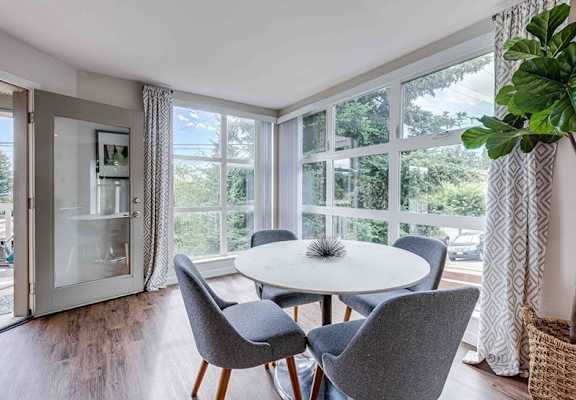 A dining room with a table and chairs.