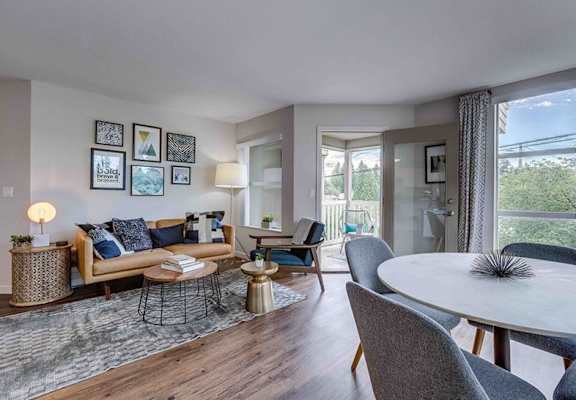 A living room with a sofa, chairs, and a table.