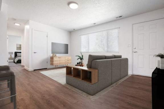 A living room with a grey couch and a wooden coffee table.