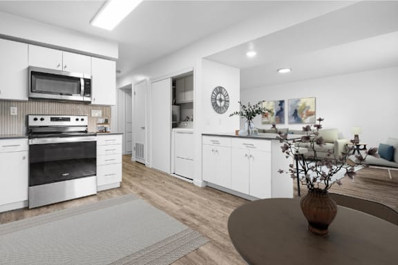 A modern kitchen with white cabinets and stainless steel appliances.
