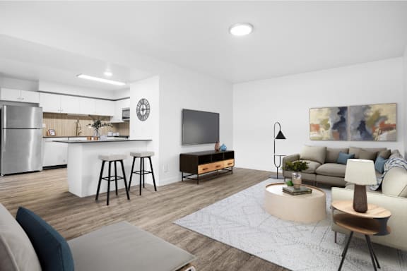 A modern living room with a kitchen area in the background.