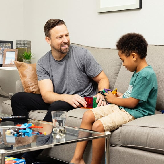 Person and child sitting on couch relaxing