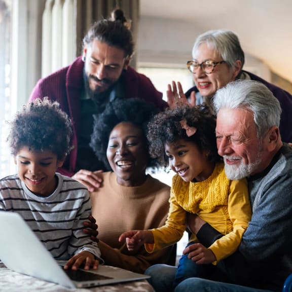 Group of people using laptop smiling and laughing