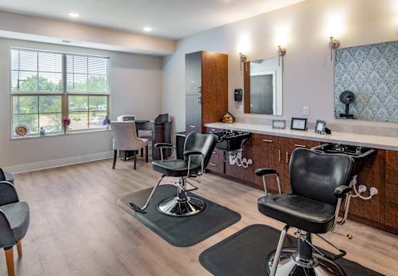 a salon room with chairs and a counter and a window