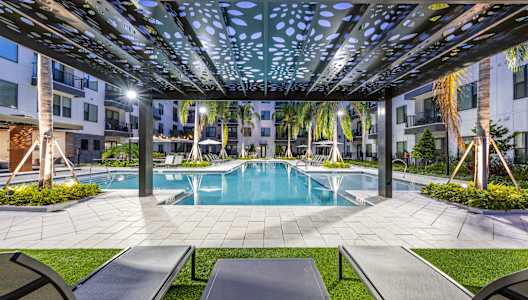 our apartments have a large swimming pool with lounge chairs and tables at 19 South Apartments in Kissimmee, FL