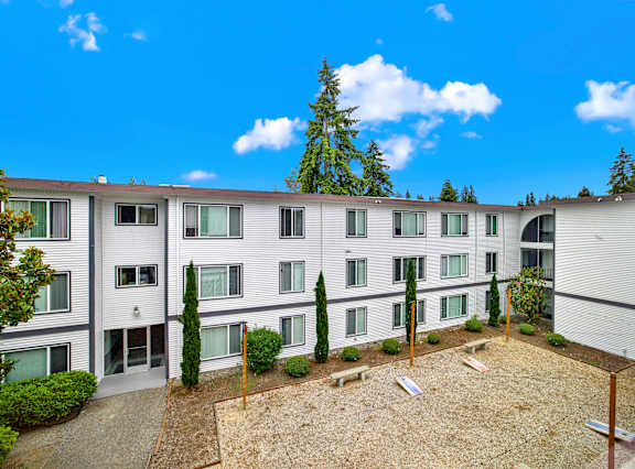Apartment complex with a courtyard and trees.