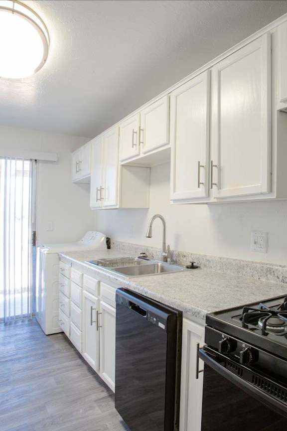 A kitchen with white cabinets and a black stove top oven.