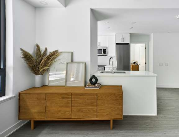 A modern kitchen with a wooden cabinet and a dining table.