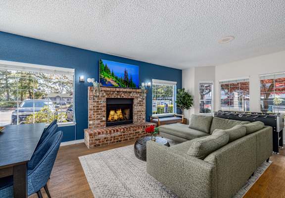 A living room with a fireplace and a painting on the wall.