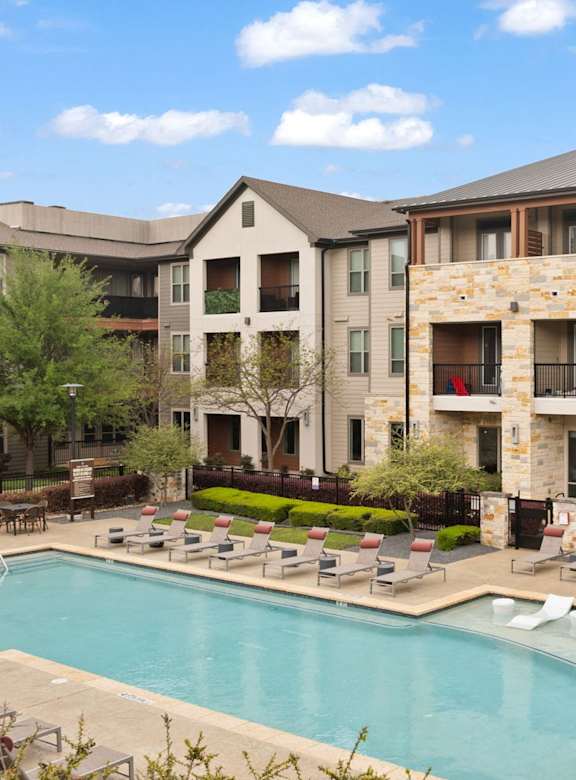Axis Marketplace Apartments in Kyle, Texas Pool with Lounge Chairs and Apartment Exteriors