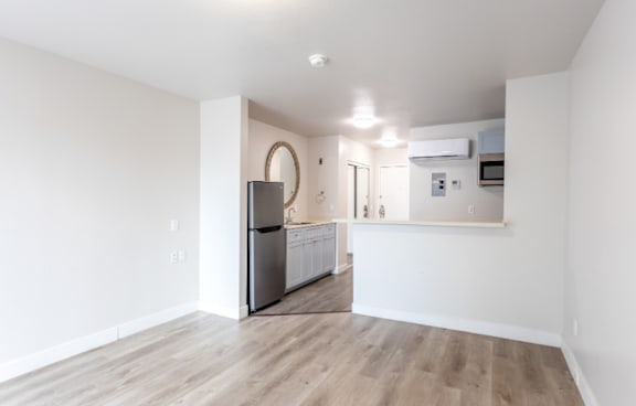 A kitchen with a refrigerator, microwave, and oven.