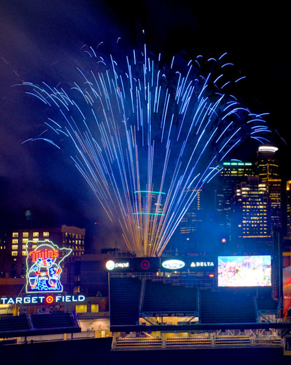 A fireworks display over a city skyline with a Target Field sign visible.
