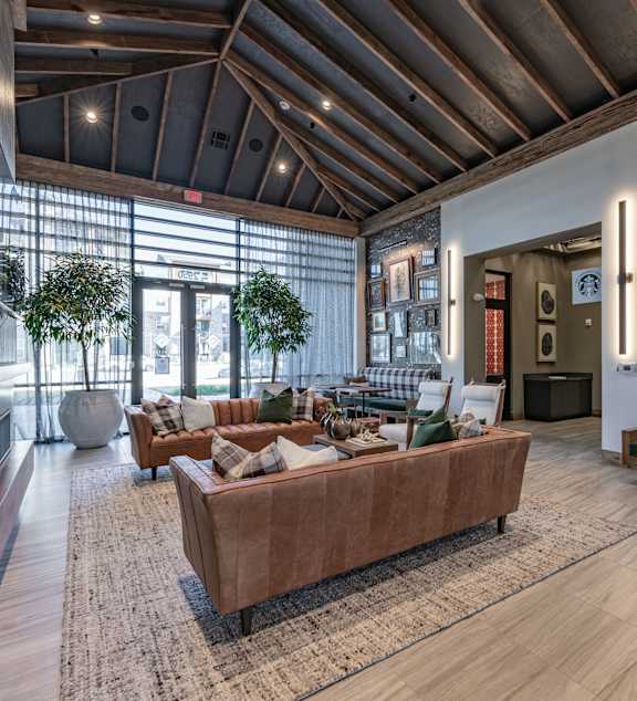 A modern living room with a glass coffee table and a grey couch.