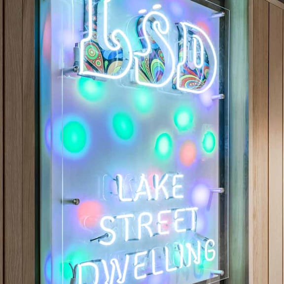A neon sign for Lake Street Dwelling is lit up.
